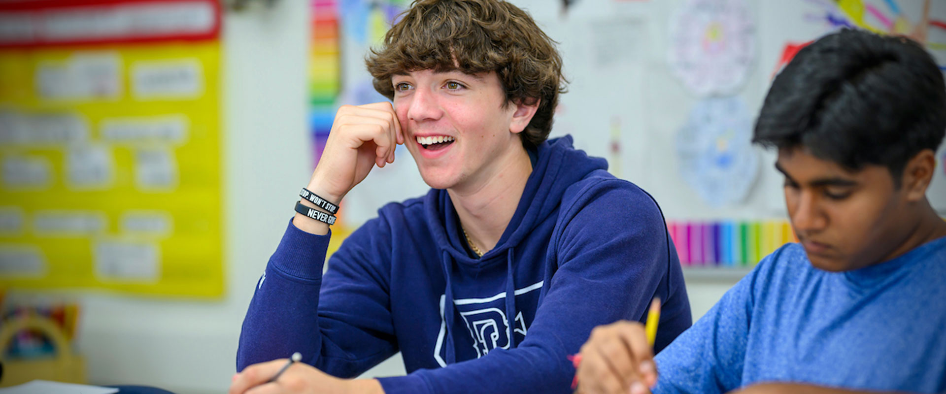 Male Upper School student at a desk in classroom