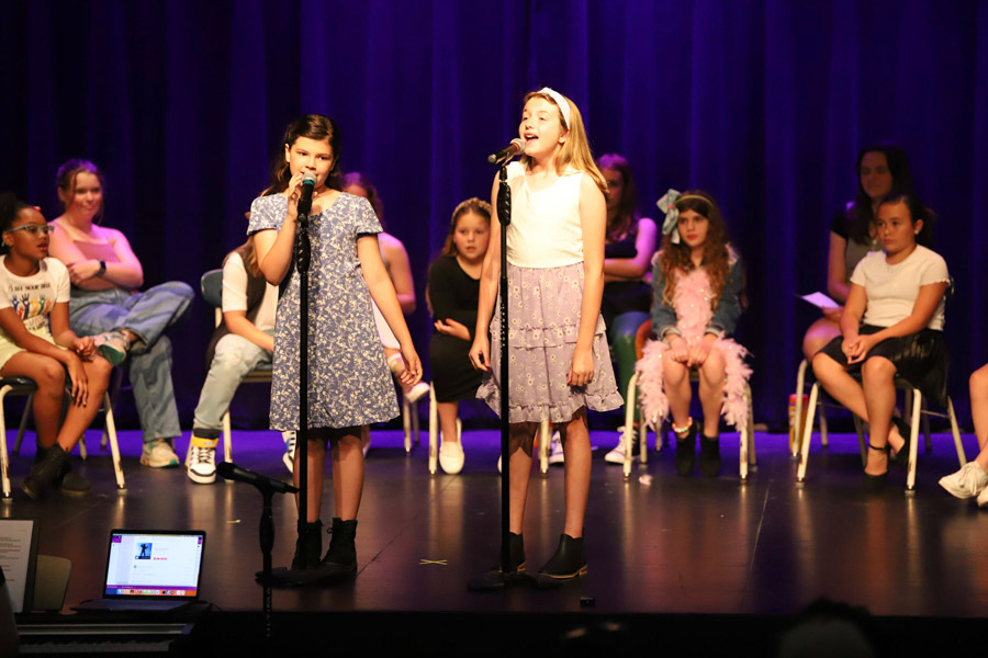 Fifth graders sing a duet on stage